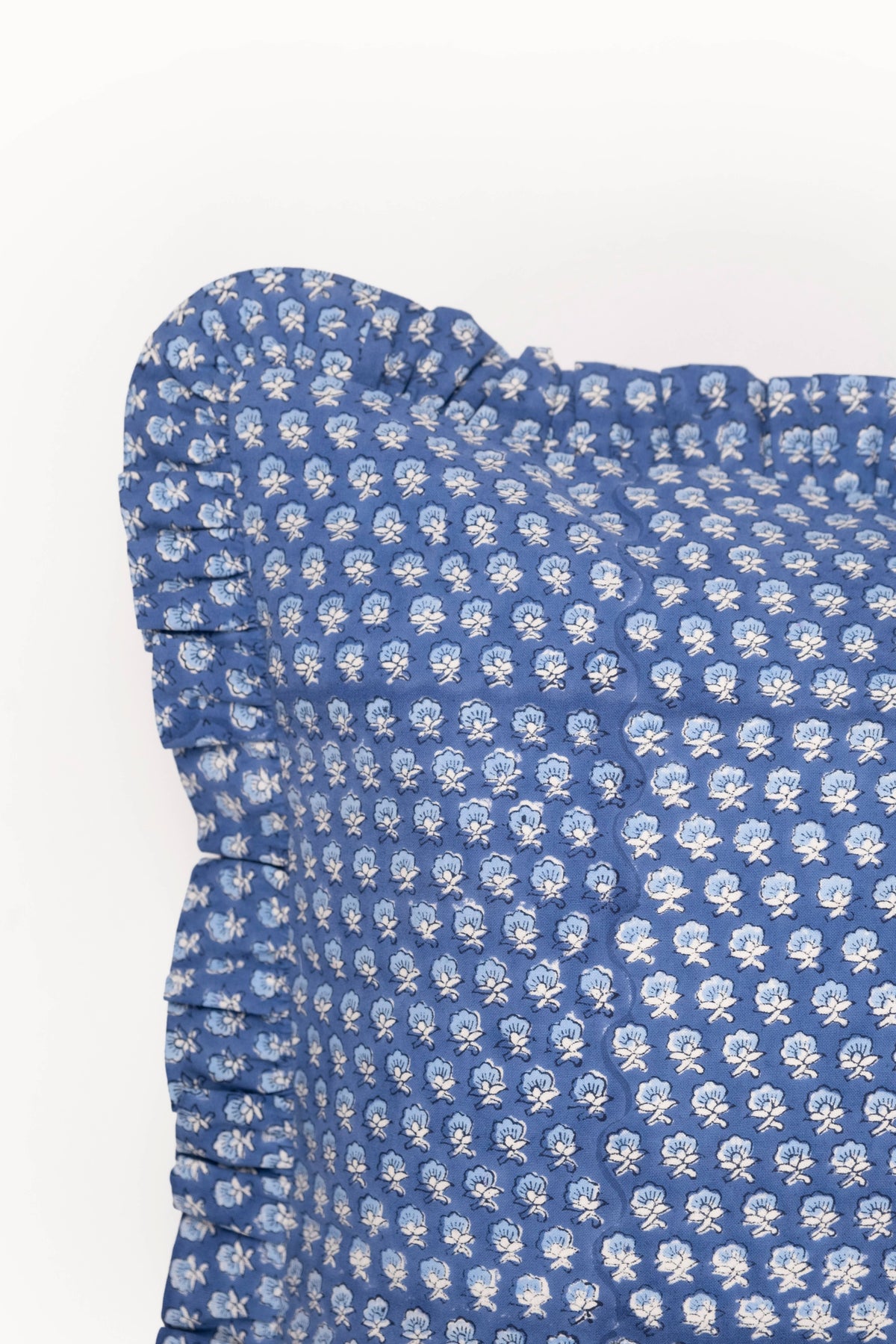 Blue blockprint pillow cover close-up with white pattern and ruffled edge