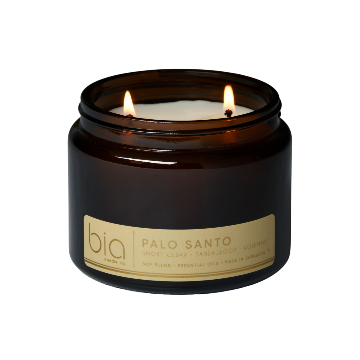 Dark glass soy candle jar with two flames and “Palo Santo” label on front