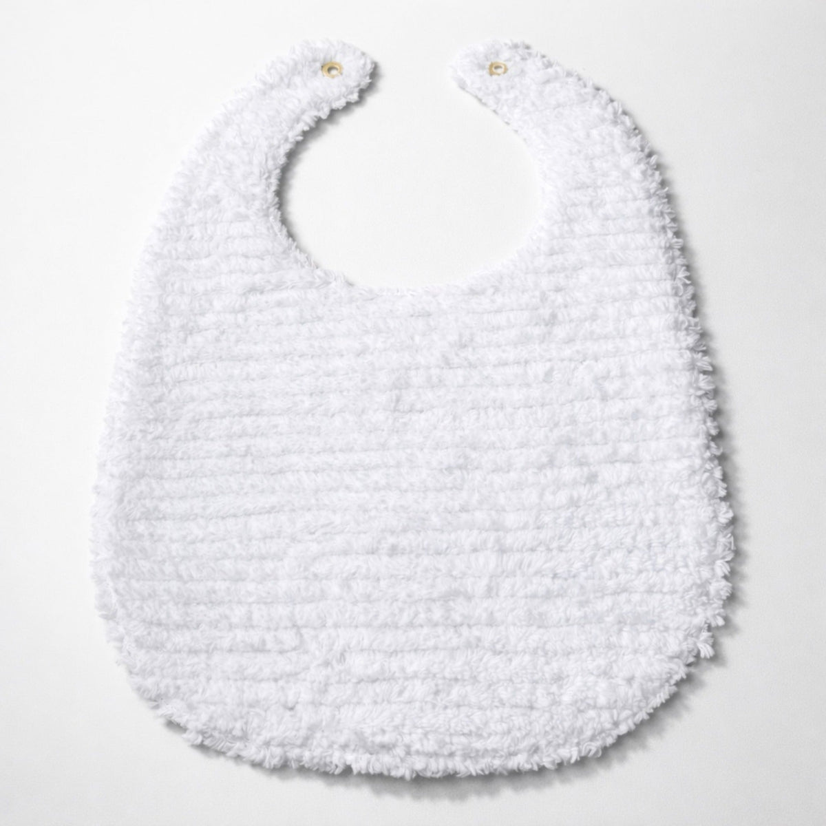 White textured baby bib with round neckline, snap button at top, and stitched fringe hem