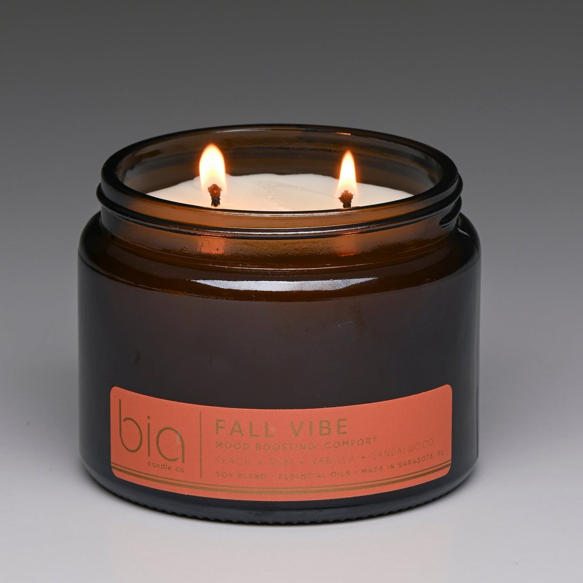 Amber soy blend candle in glass jar with two flames and 'bio' label