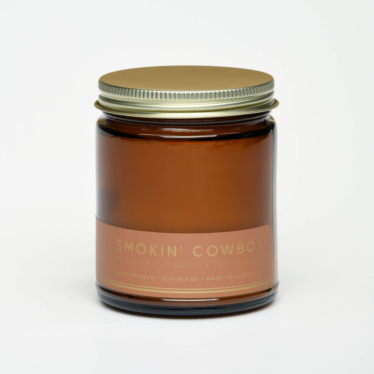 Amber glass candle jar with gold lid and 'Smokin' Cowboy' label