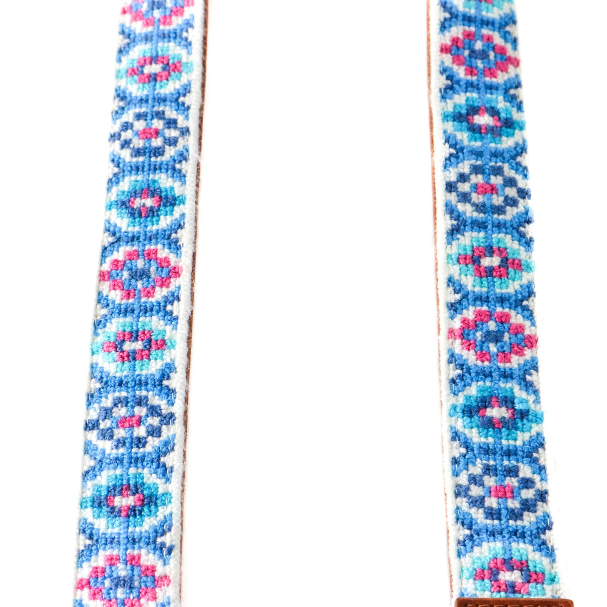 Woven bag strap fabric with blue and pink geometric pattern and tan leather edging