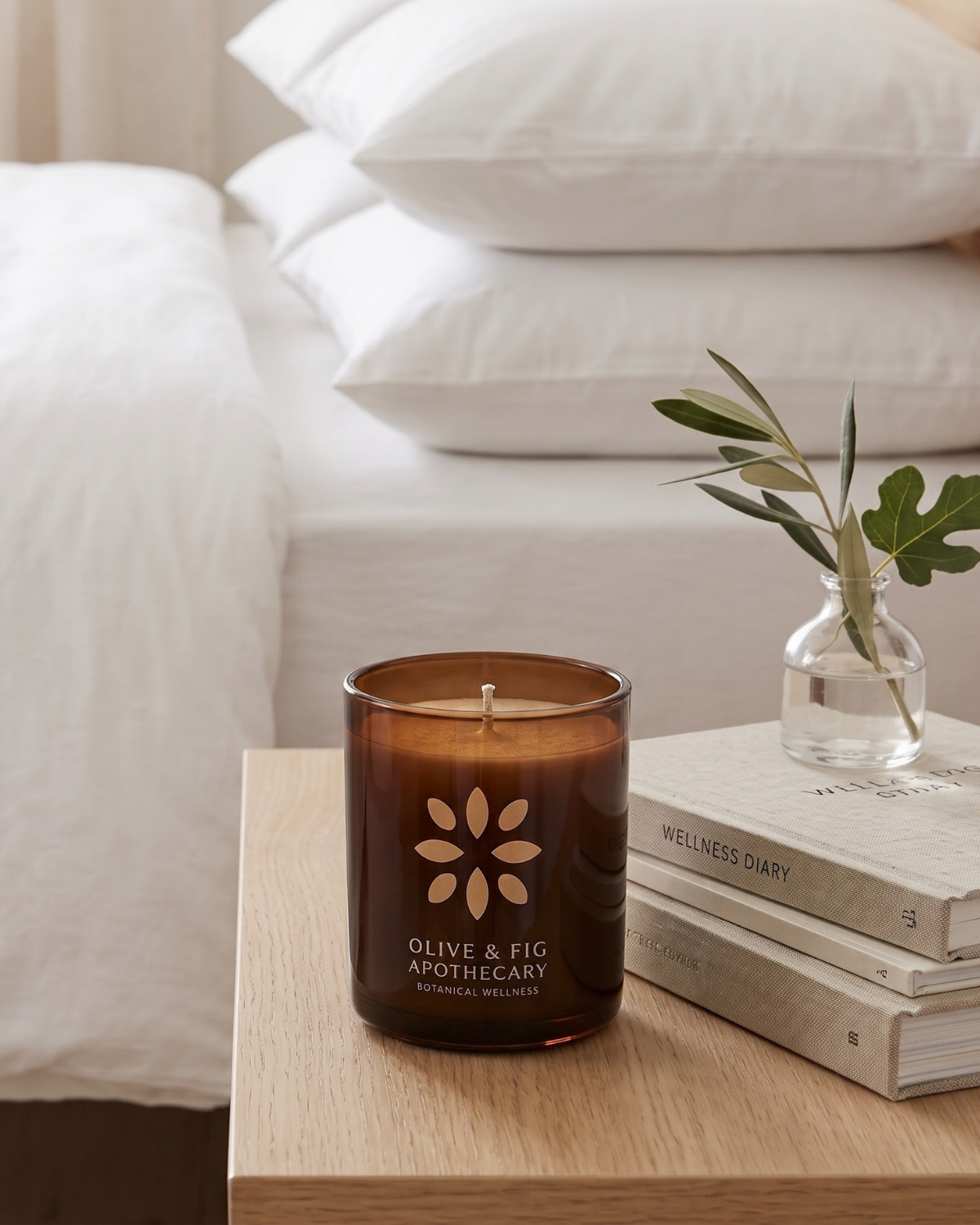 Amber glass jar candle with floral emblem, unlit, on a wooden surface