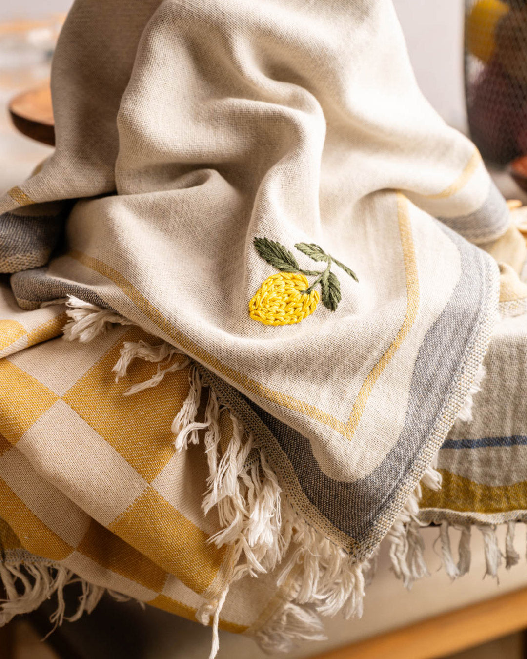 Kitchen towel close-up: lemon embroidery, green leaves, yellow check border, fringed edge