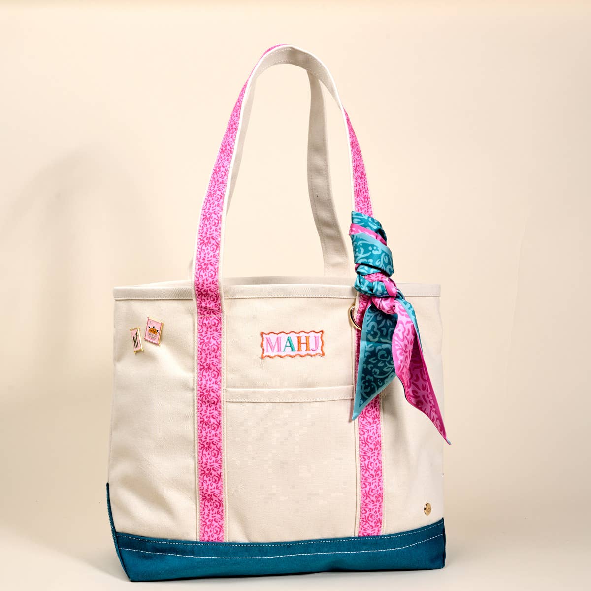 Cream canvas tote bag with MAHI patch, pink glitter handles, teal bottom, bow accent