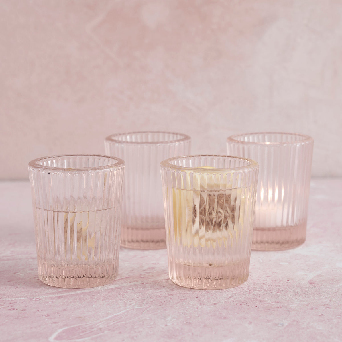 Pink pressed juice glasses, four ribbed tumbler cups with faceted bottoms