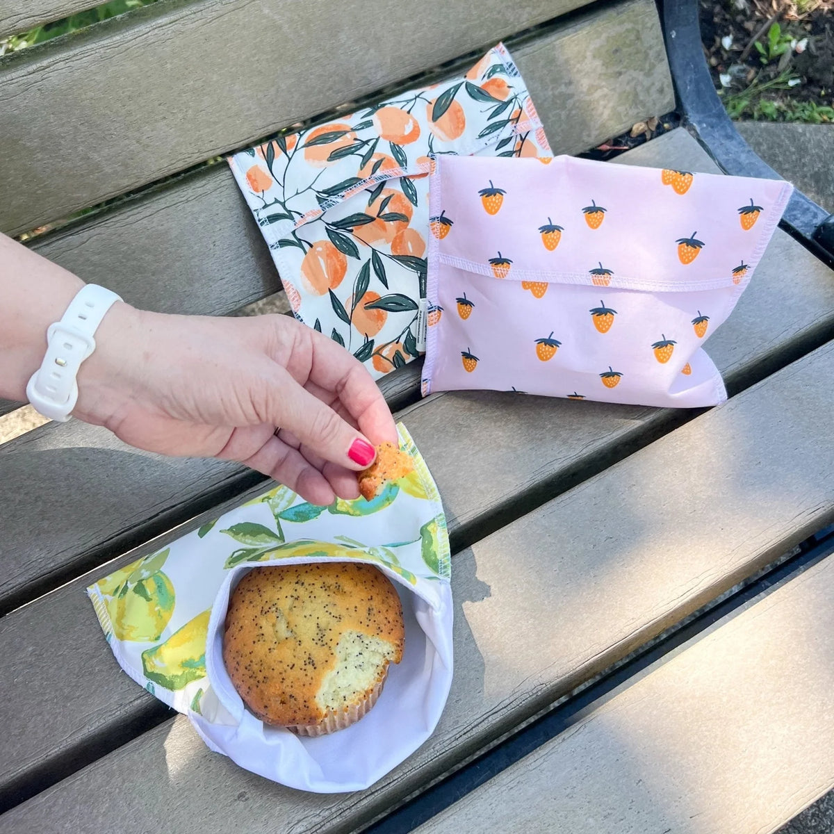 Reusable snack bag with citrus-themed print, open bag holding a sandwich bun