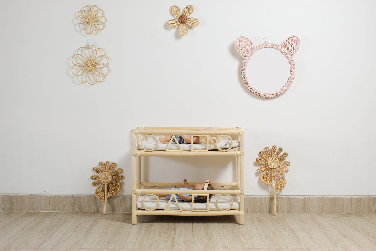 Pink rattan teddy bear wall mirror above a woven nursery shelf