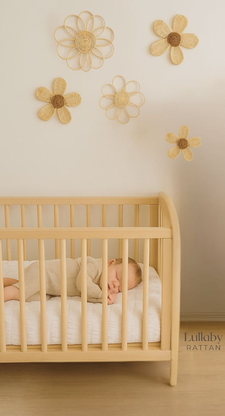 Natural rattan daisy wall hangings above a nursery crib