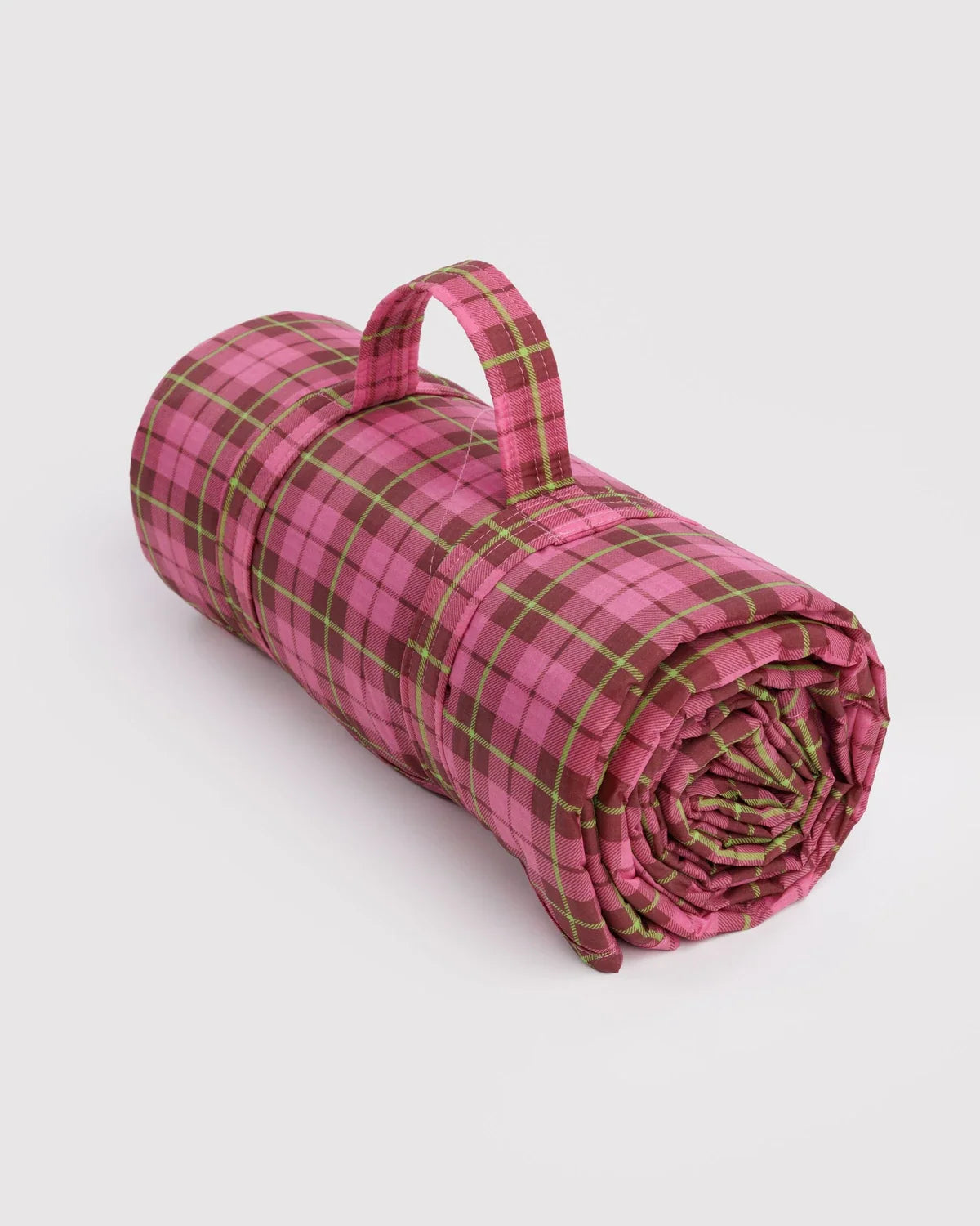 Baggu puffy picnic blanket rolled with a carry handle, in pink tartan plaid