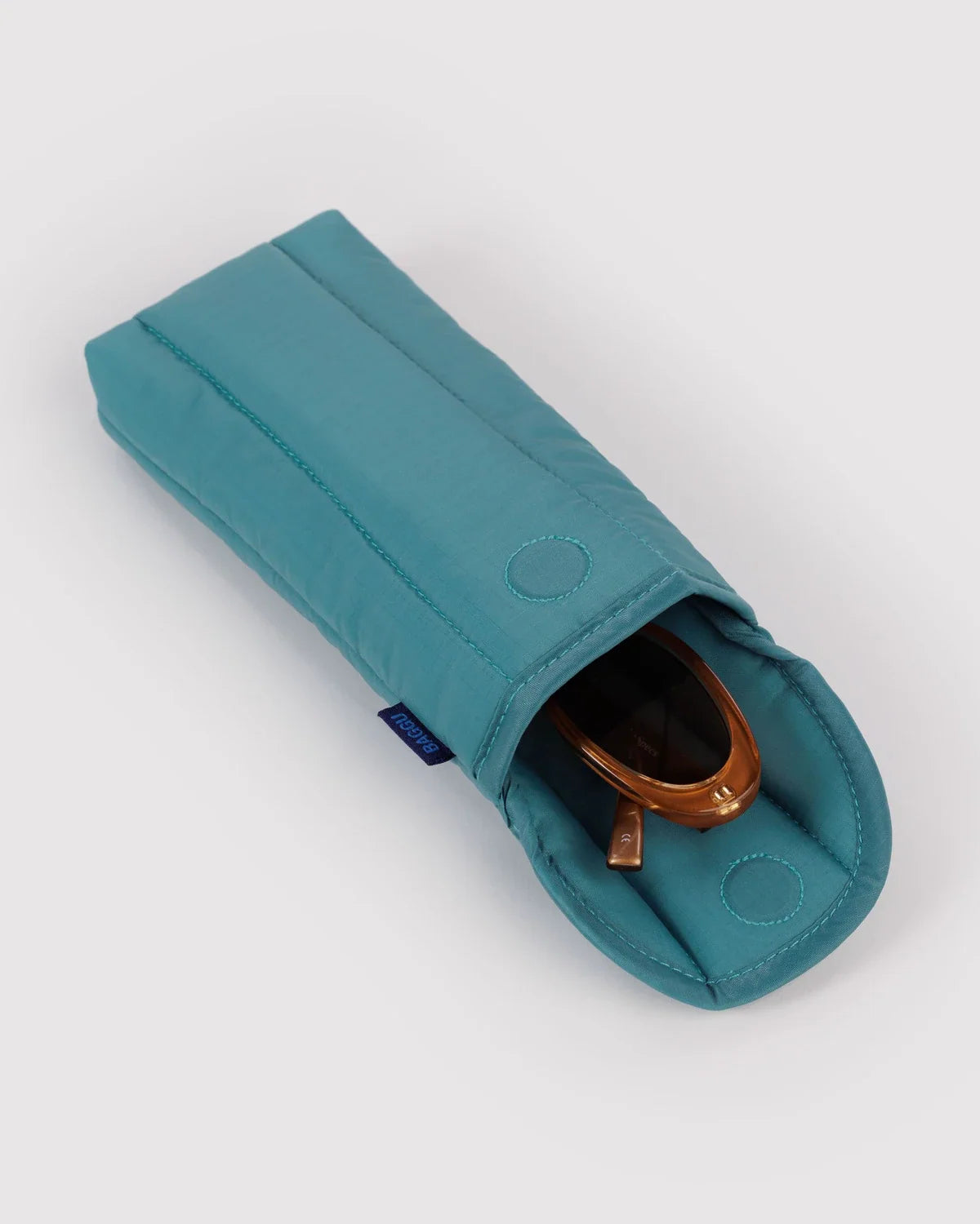 Open teal Baggu puffy glasses sleeve holding brown glasses