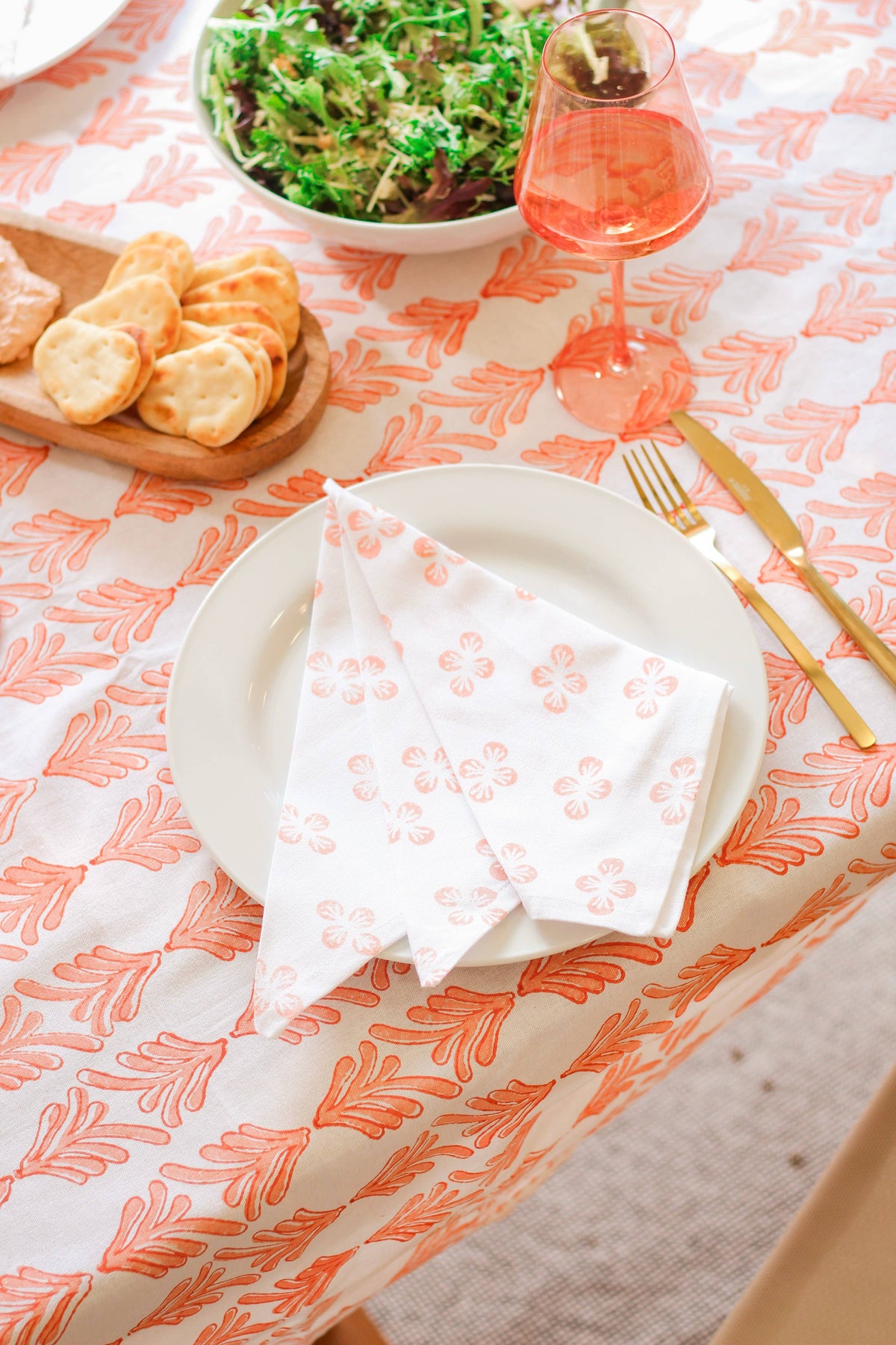 Orange leaf-pattern table throw on table, styled with plate and bread nearby