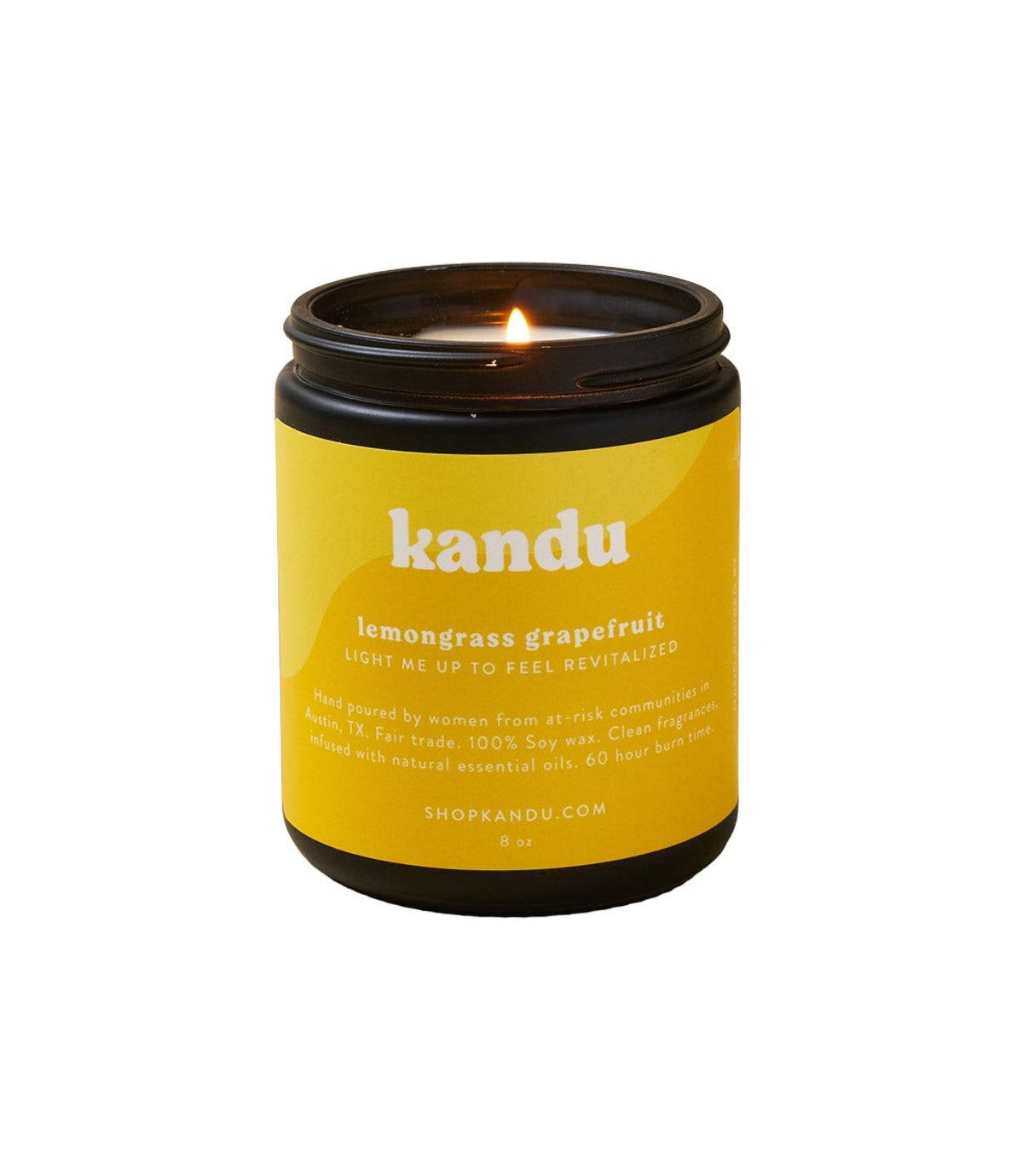 Yellow candle in black-lidded jar with burning flame visible above the label.