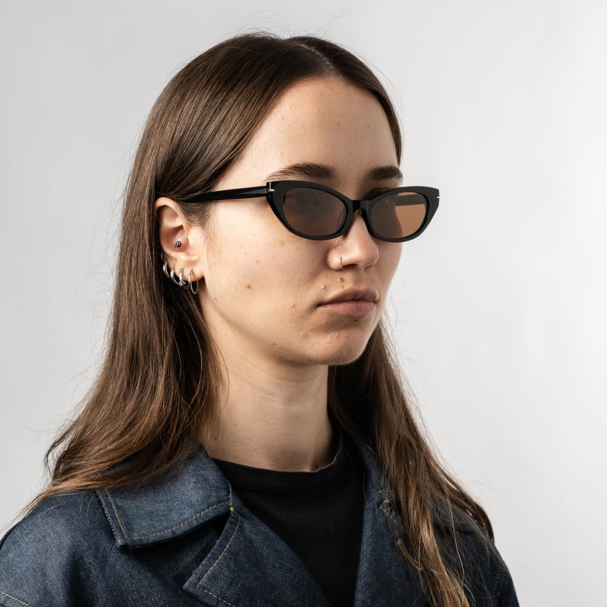 Person wearing black polarized sunglasses with bronze lenses, three-quarter side angle.