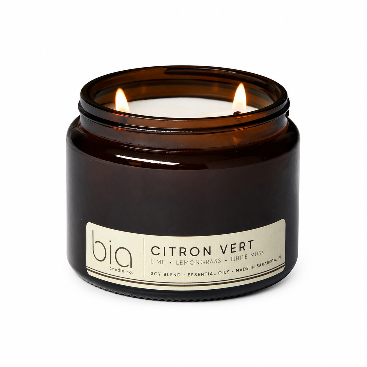 Amber glass soy blend candle with flame and front label reading Citron Vert