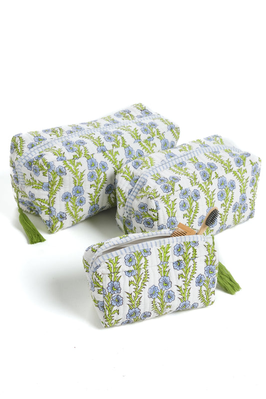 Blue floral blockprint makeup bag with zipper and green tassel, angled view.
