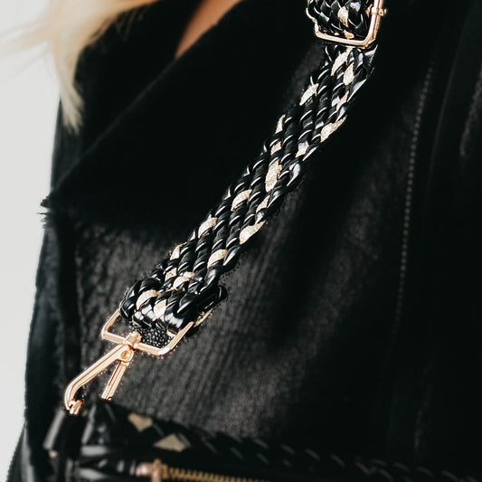 Braided black strap with gold-tone clasp and metal hardware close-up