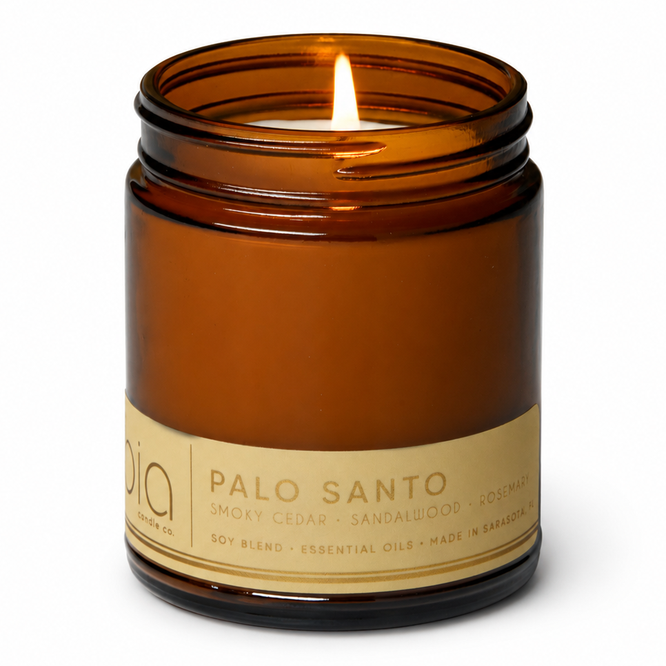 Amber glass soy blend candle jar with lit flame and black lid ring