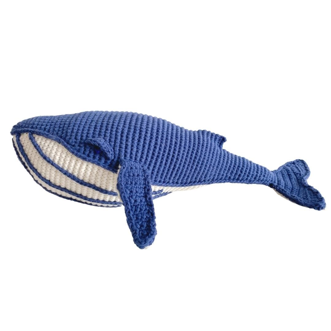 Deep blue crocheted whale plush with a cream striped belly and long fins.