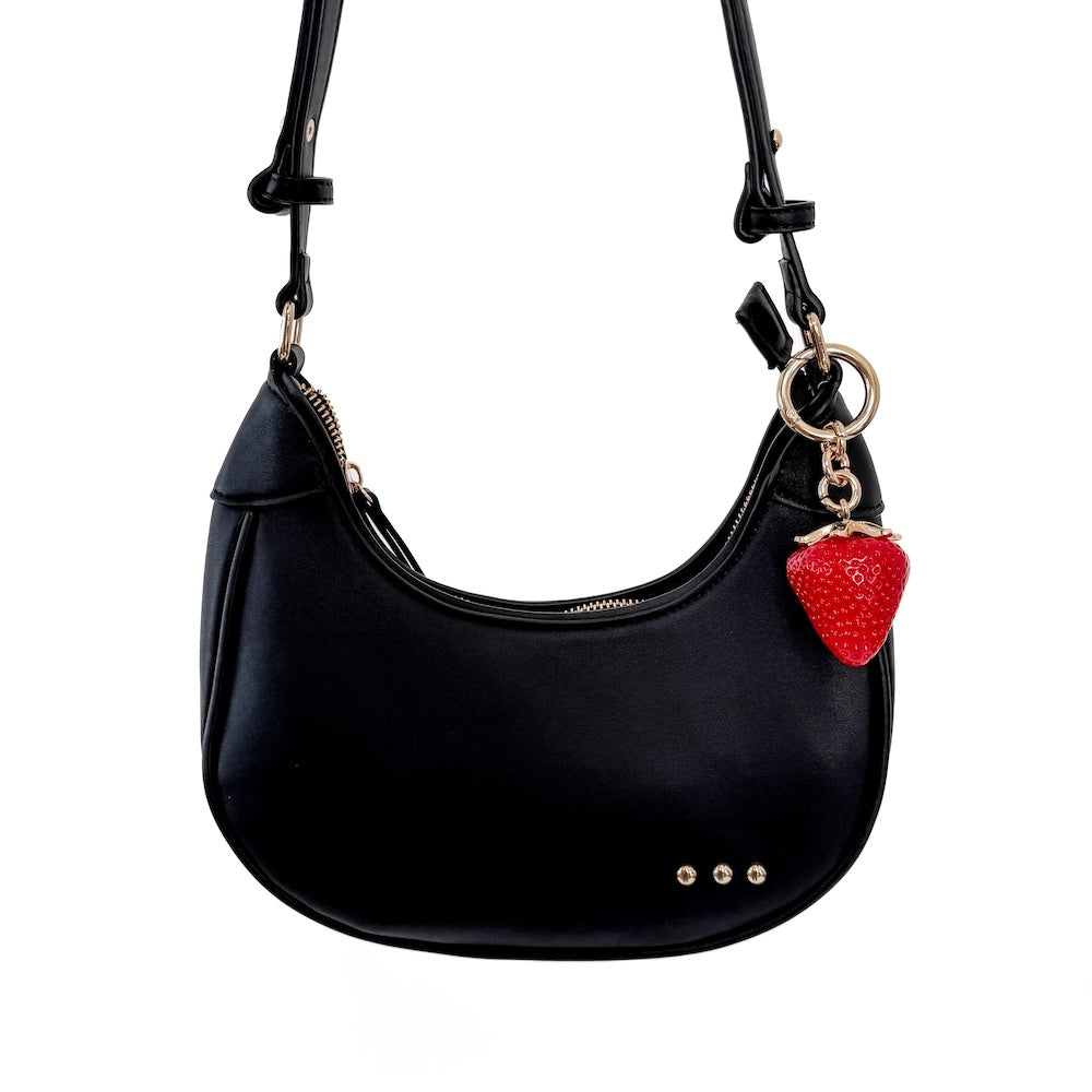 Strawberry bag charm on black hobo bag, red charm with gold chain and keyring