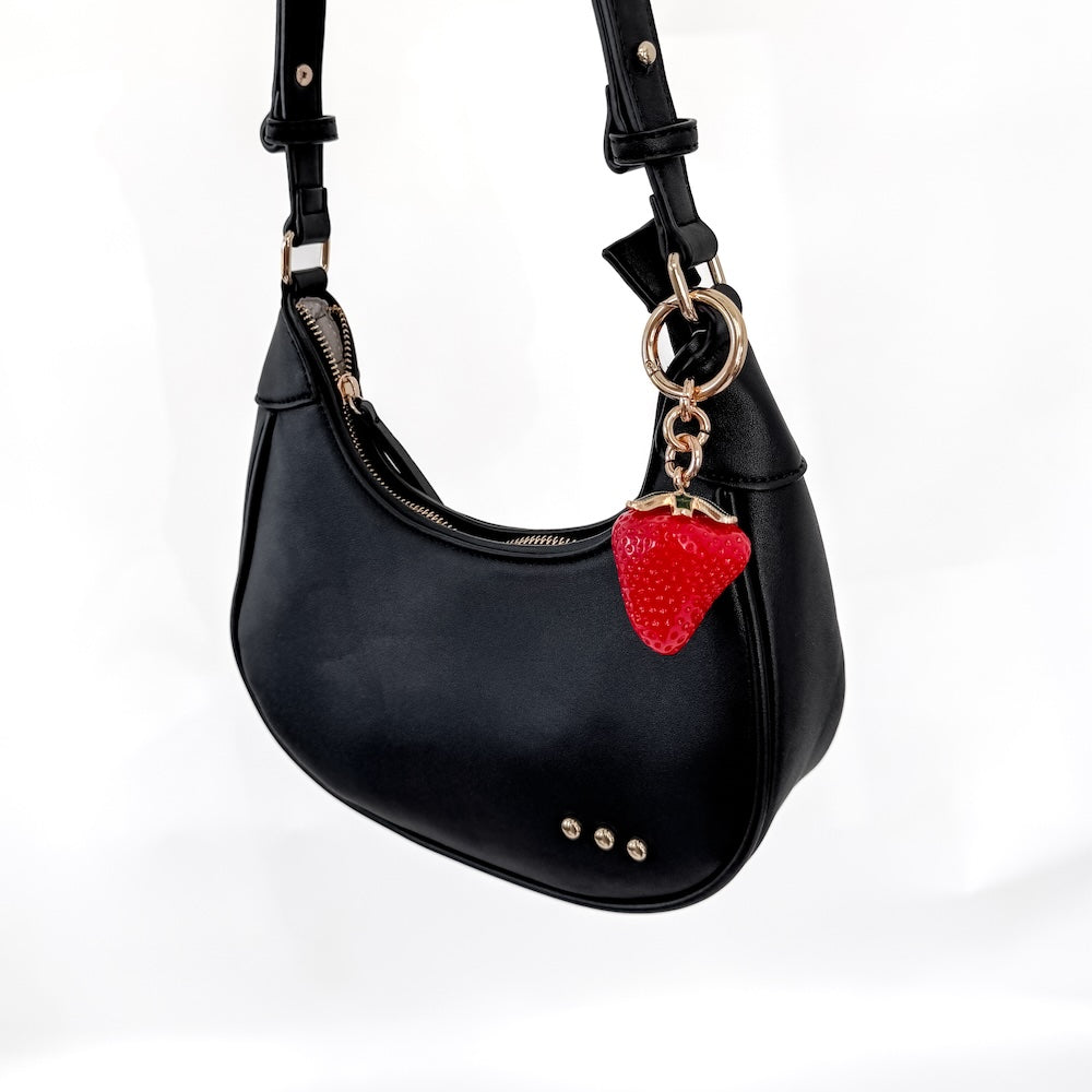 Strawberry charm on black shoulder bag, red strawberry with green leaf and gold ring