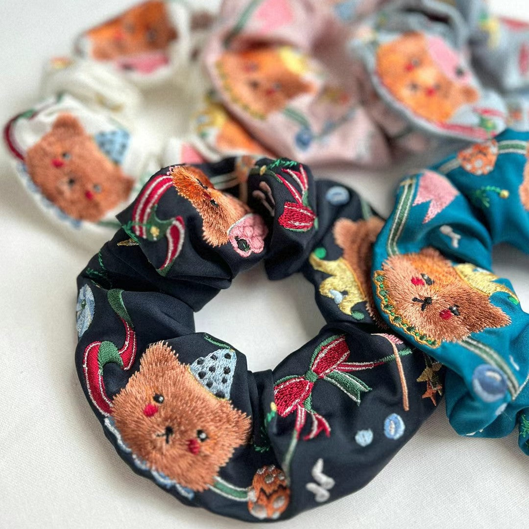 Dark scrunchie with embroidered circus bear faces, stars, and candy-striped accents