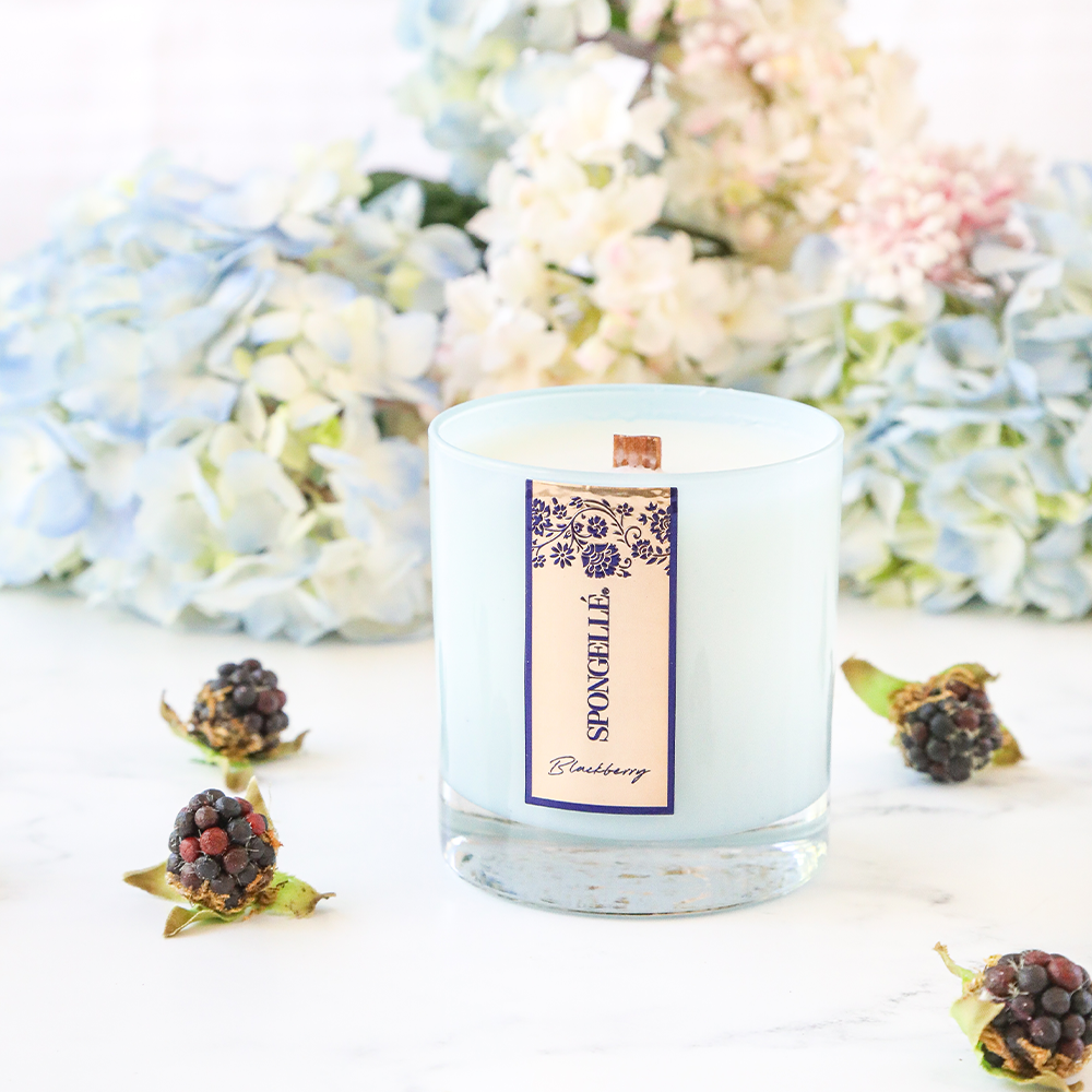 Scented candle in blue glass jar with blackberry label and visible wax top