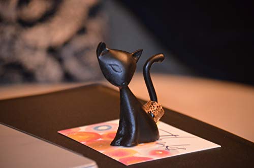Dark cat ring holder figurine standing on a flat surface, curled tail and head detail.
