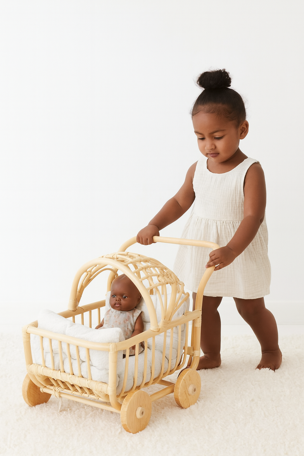 Natural rattan doll stroller with arched canopy, white bedding, and wooden wheels, pushed by a child