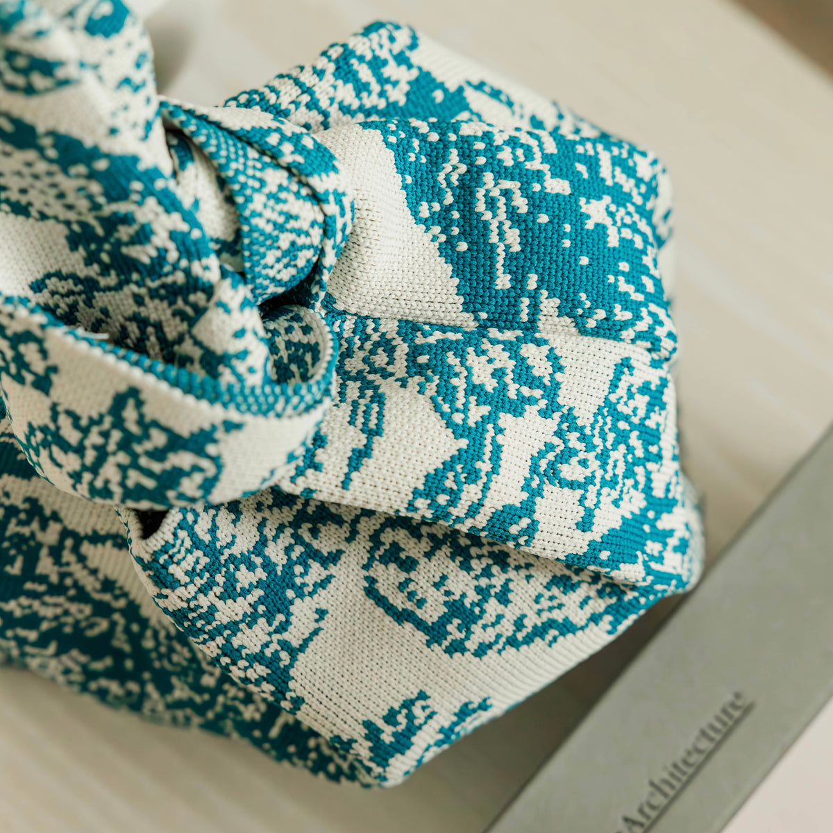 Close-up of blue-and-white woven handbag pouch fabric with knotted drawstring