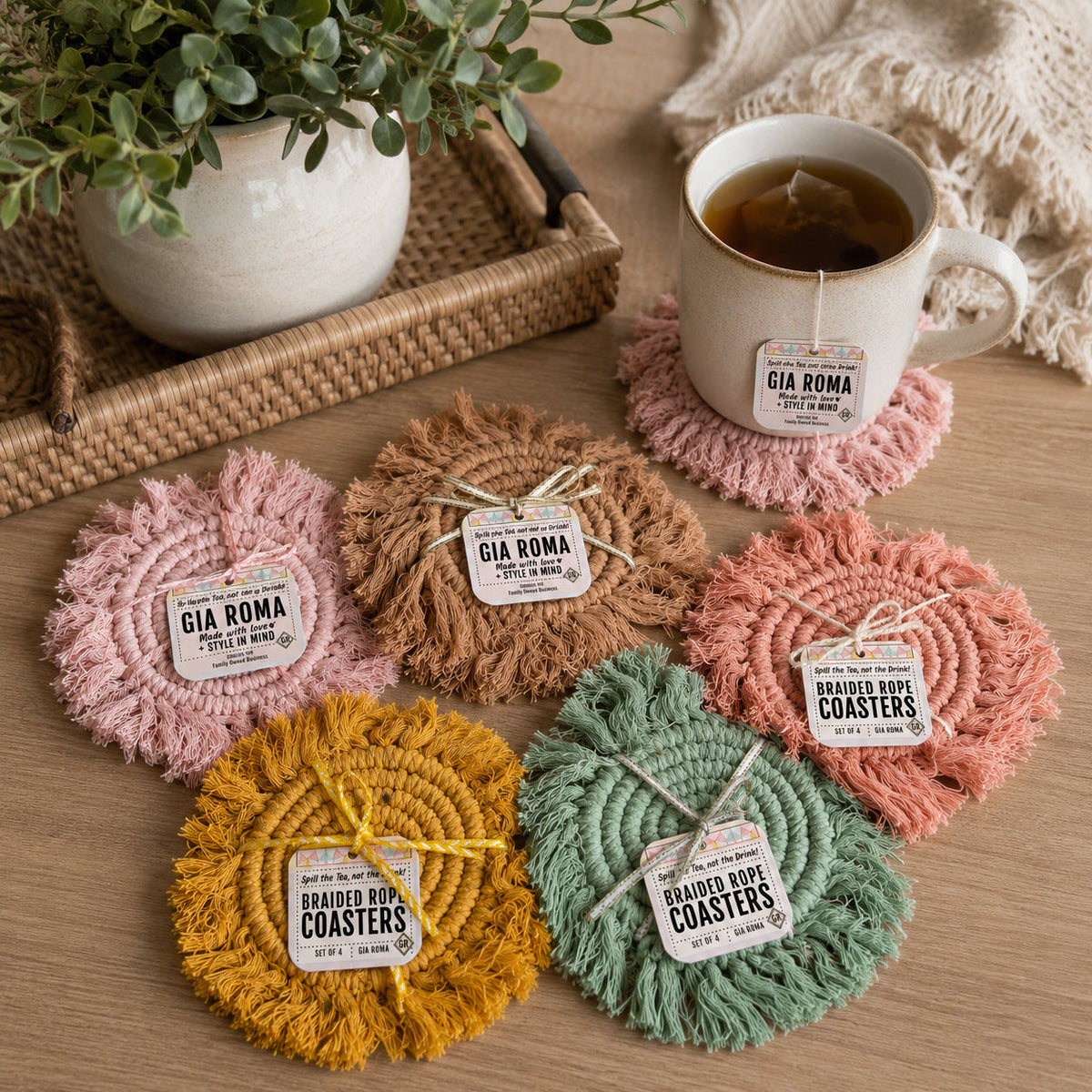 Assorted round braided rope tassel coasters with labels in pink, brown, mustard, and green