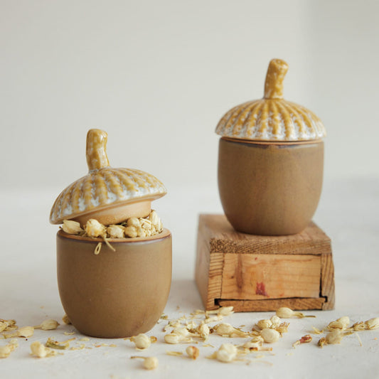 Two stoneware acorn jars; acorns visible in one, both with speckled lids