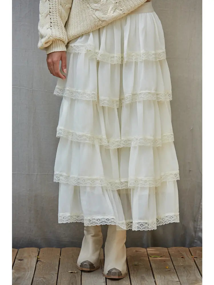 White maxi skirt detail showing gathered sheer tiers with lace-trimmed hems