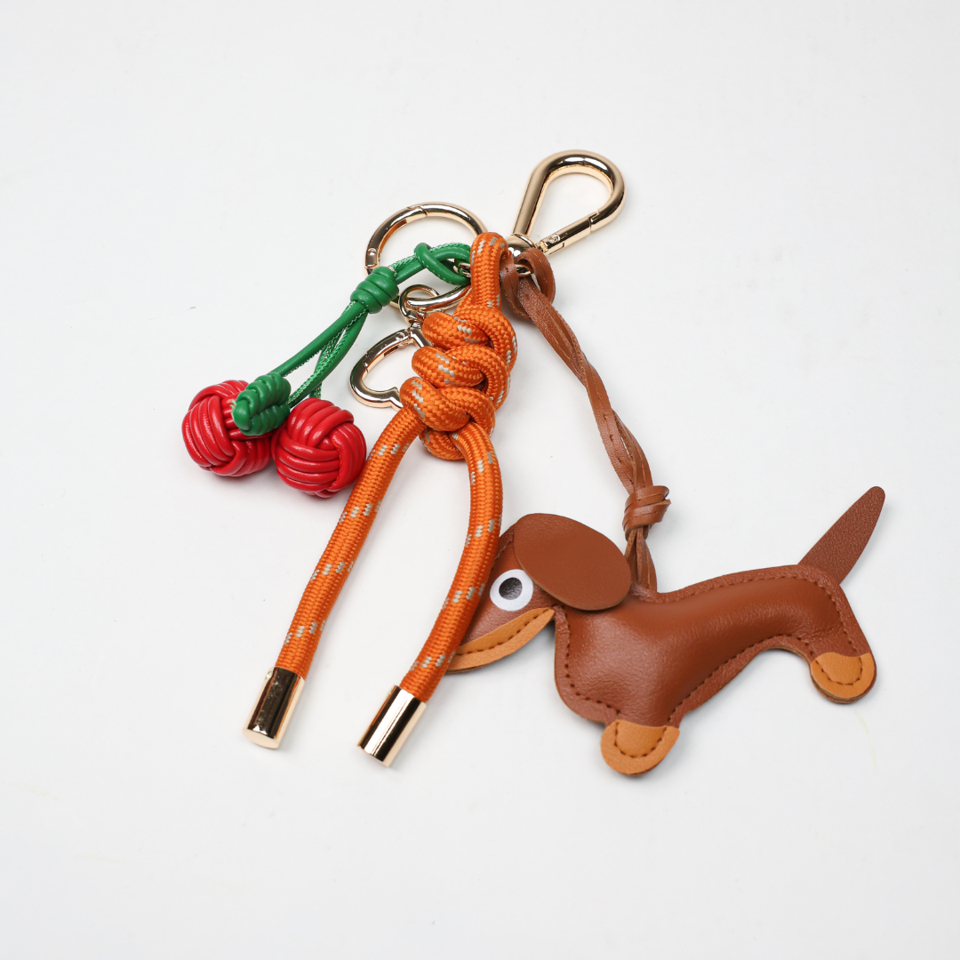 Burnt orange key chain with brown dog leather charm and red cherry braid