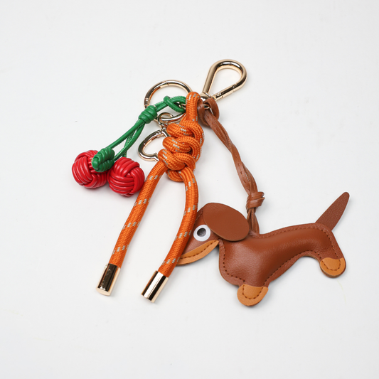 Burnt orange key chain with brown dog leather charm and red cherry braid