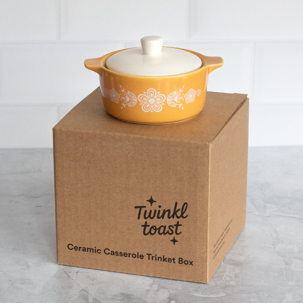Yellow ceramic casserole trinket box with white lid on kraft box packaging