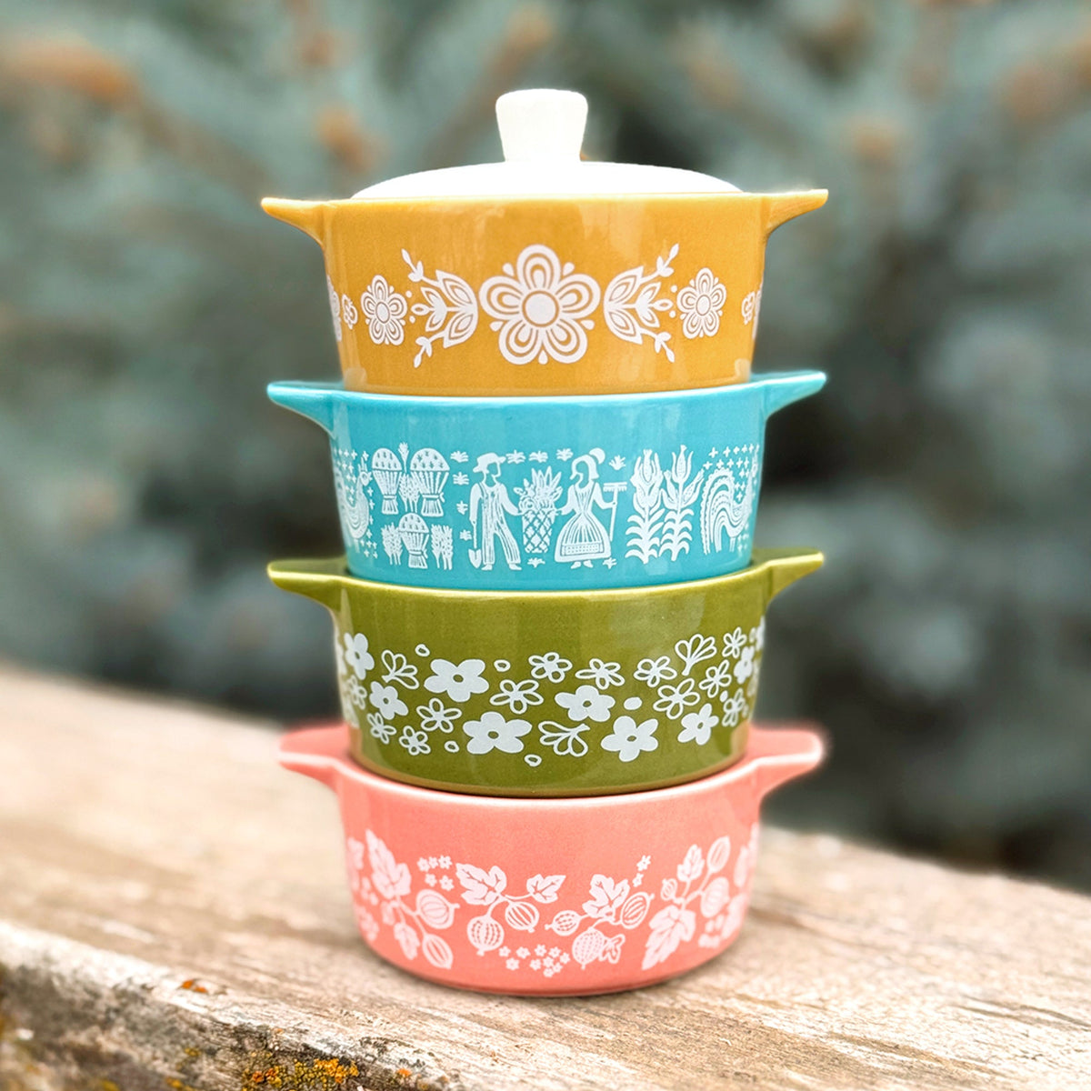 Stack of ceramic casserole trinket boxes with white, blue, and coral floral patterns