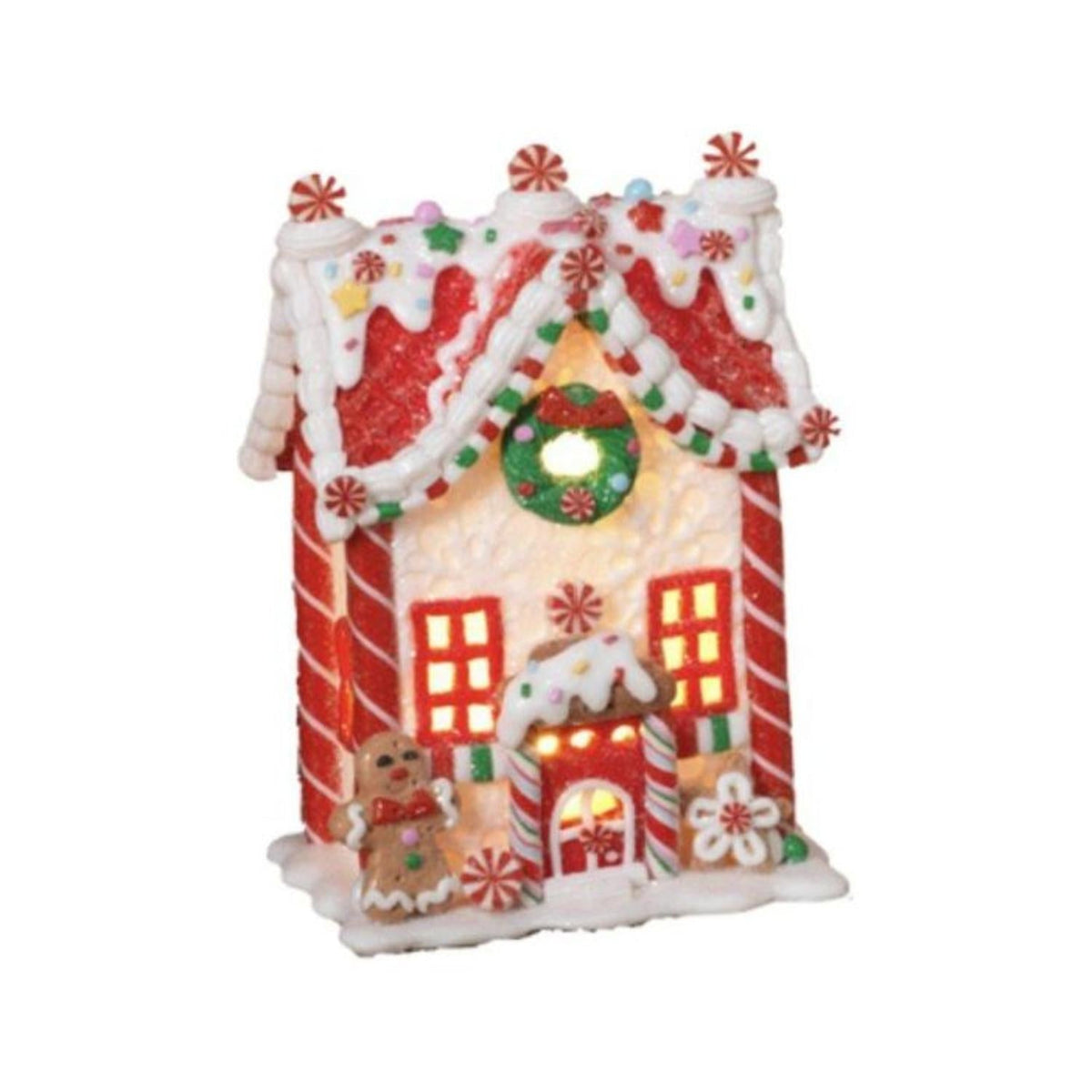 Front view of a miniature gingerbread-style house with candy trim and glowing doorway