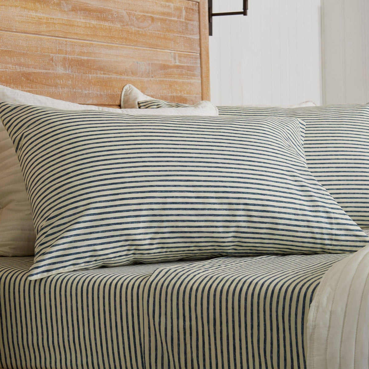 Blue striped microfiber sheet set on a bed with pillowcase and duvet cover
