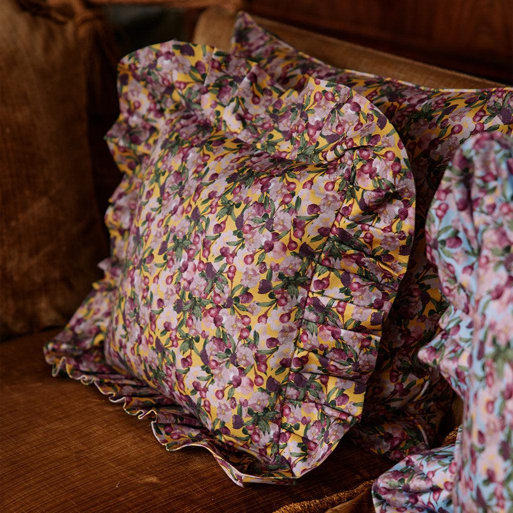Floral ruffled pillow cover, yellow background with purple flower clusters and pleats