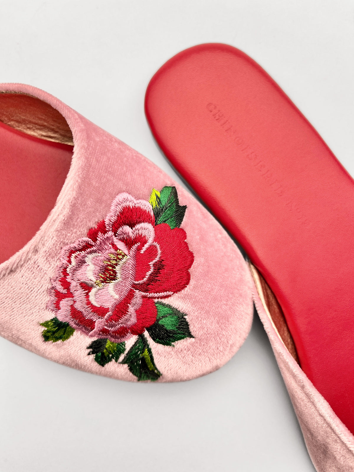 Close-up of lavender pink velvet mule with red and white peony embroidery