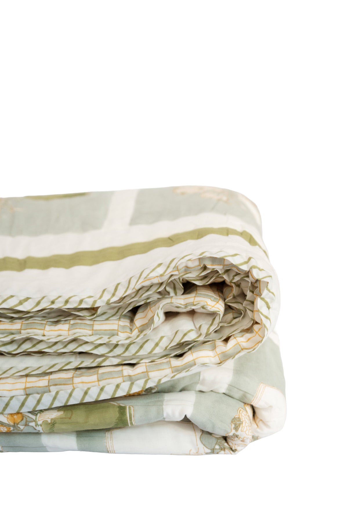 Folded quilt showing layered stitching in green, white, and yellow with stitched edges
