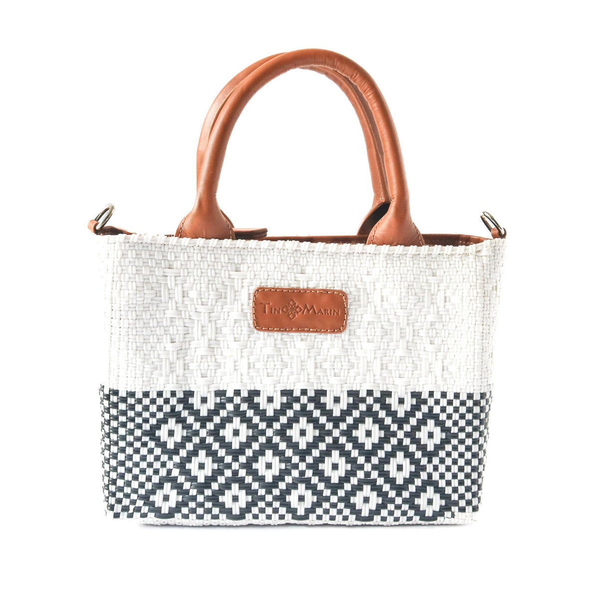 Small woven crossbody bag front view, white weave with black pattern and tan leather handle