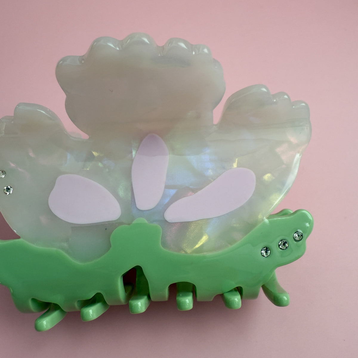 Opalescent flower hair claw with green base, lavender petal inlays, and silver rhinestones