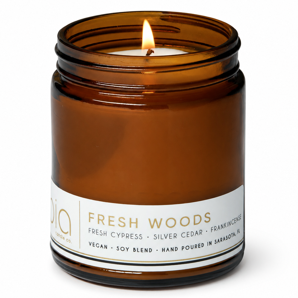 Amber glass candle jar with a centered flame and a white label around the base.