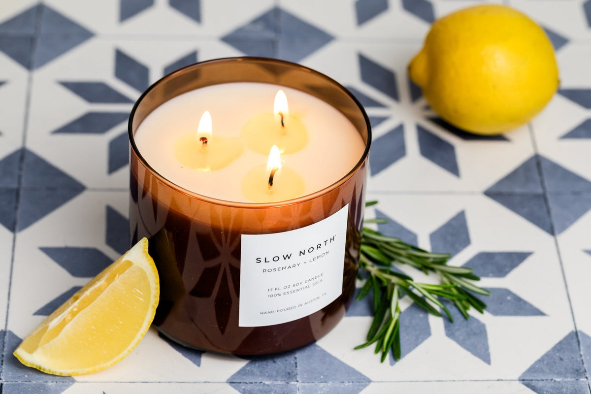 Brown 3-wick soy candle with three lit wicks and front label