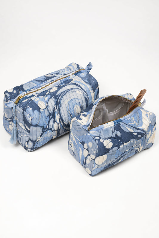 Blue cosmetic bag with gold zipper, open pouch showing lining and marbled pattern