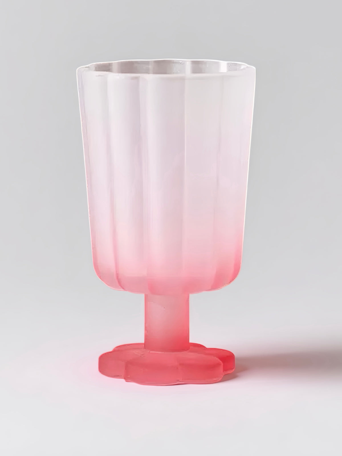 Translucent pink petal goblet with flared rim and red stem pedestal base