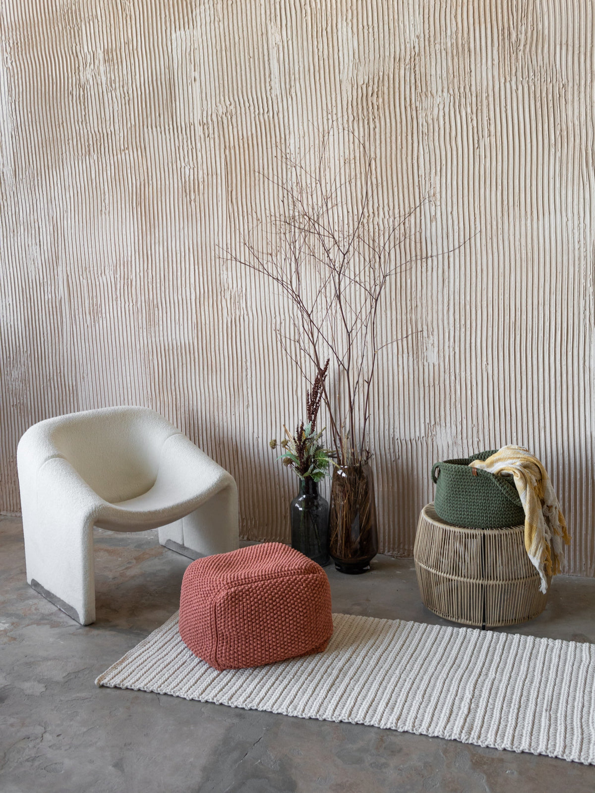 Round woven basket with handles, olive-green round basket on the floor.