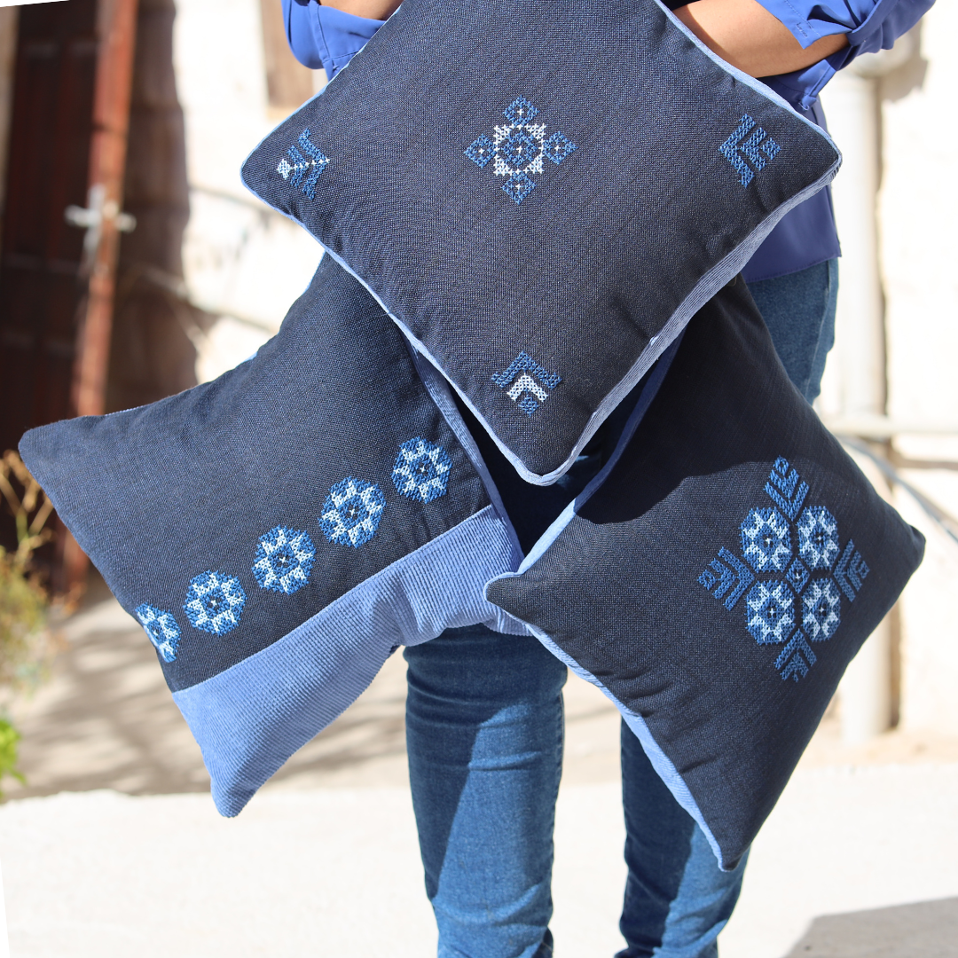 Blue pillow cover with small cross-stitch geometric motif embroidery on the face